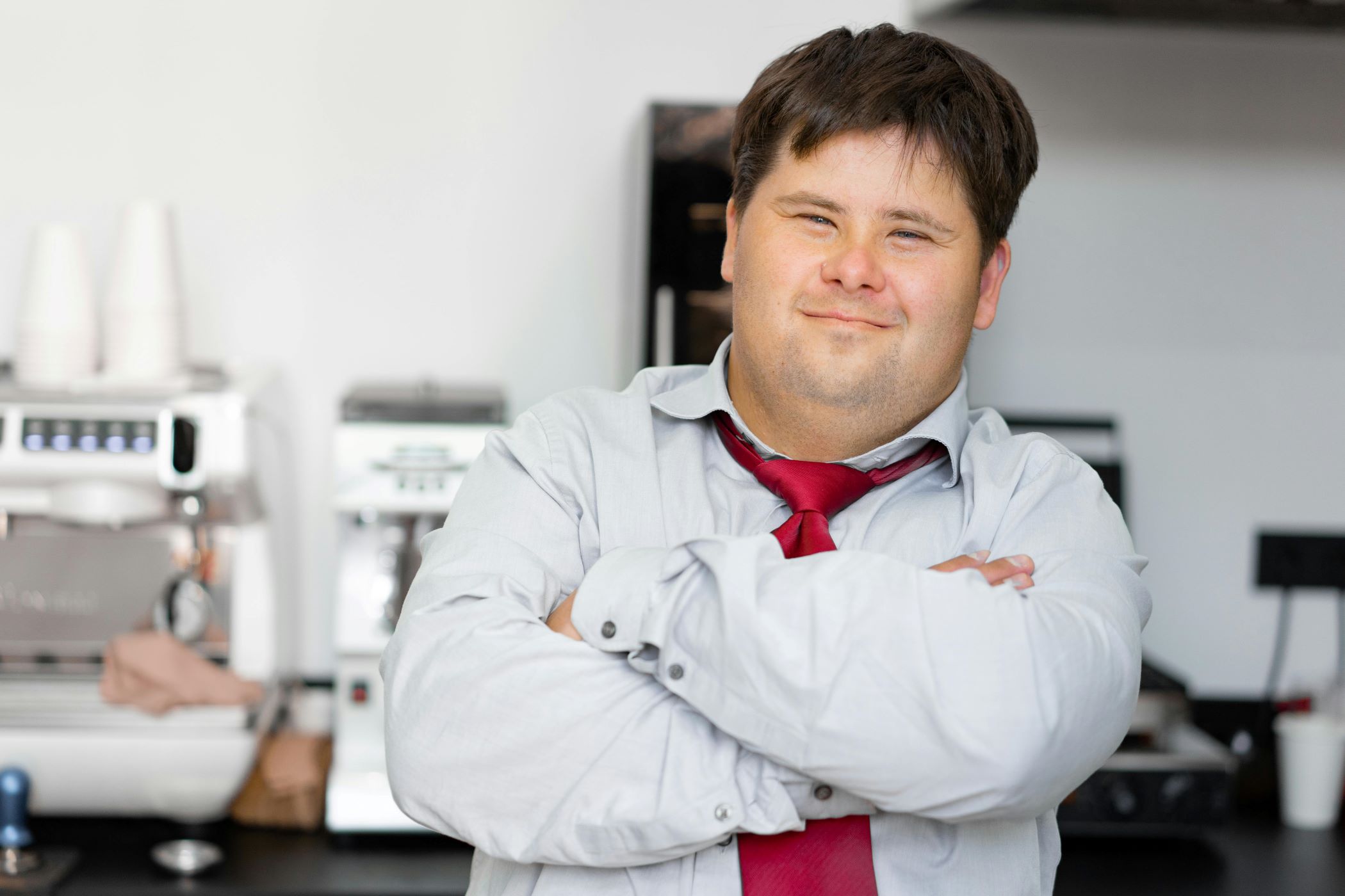 Man with Down syndrome wearing tie who works at coffee shop.